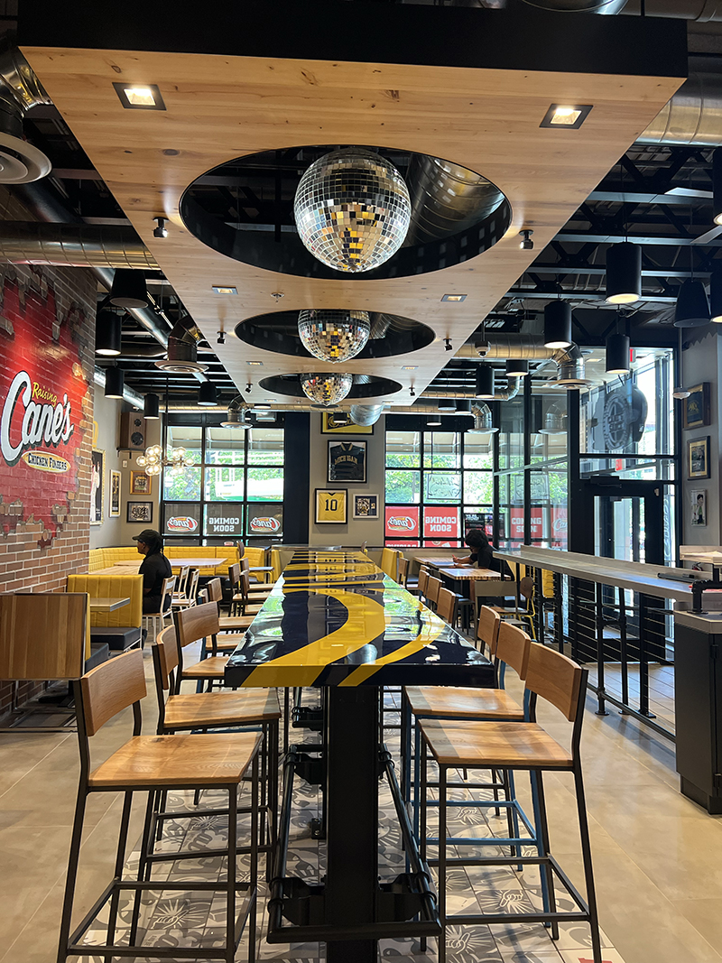A maize and blue dinning table inside the new Raising Cane's location in Ann Arbor.