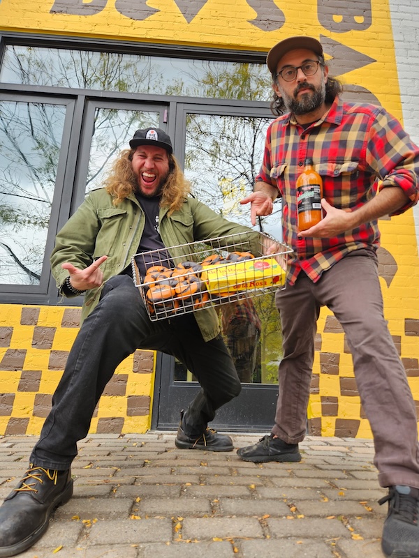 Two men stand outside Bev's Bagels