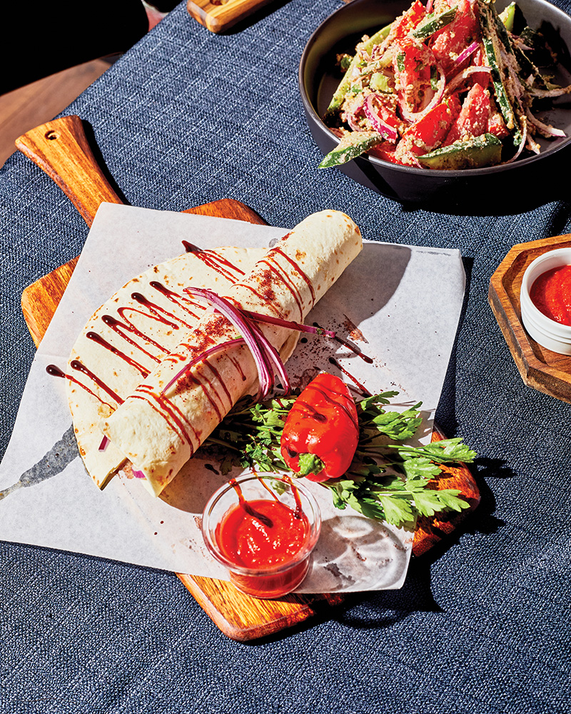 This beef kebab is rolled in thin flatbread and served with herbs and vegetables.