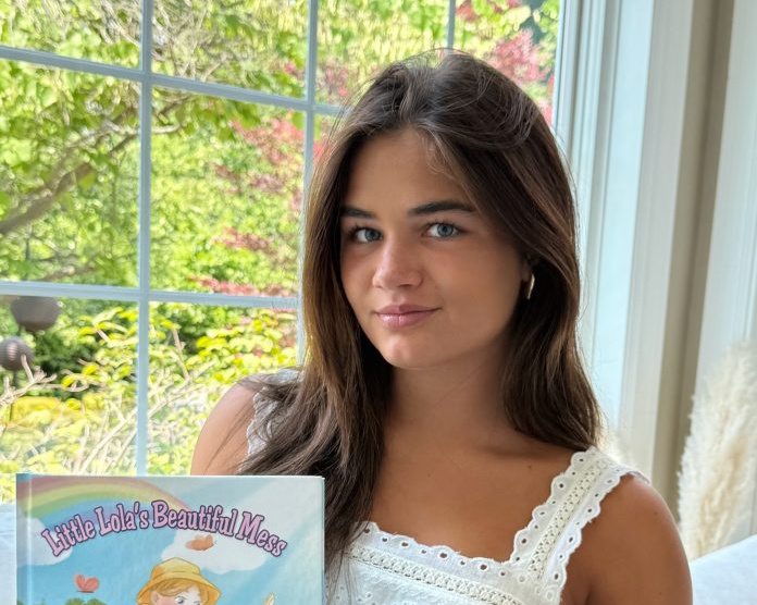 Lila Shea posing with her book