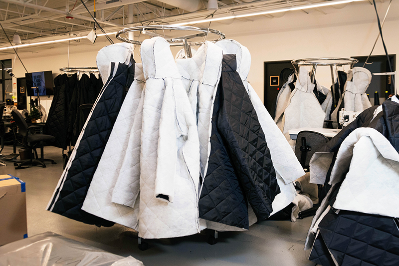 Several EMPWR Coats hanging up on the production floor of Empowerment Plan in Detroit.