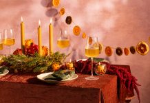 How to Integrate Eco-Friendly Items Into Your Holiday Décor A table scape with earthy decor, candles, and wine glasses.