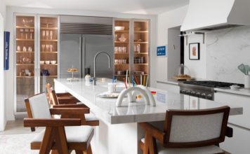 Wide-plank white-oak flooring complements the Orley Shabahang runners. The teak stools have arms and include white boucle seats and backs.