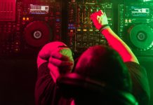 DJ Mixing House and Techno Music in a Club. Controlling the Music.