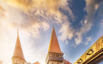 5 European Castles to Visit on Your Next Vacation Bridge leading across moat to Corvin Castle in hunedoara at dawn