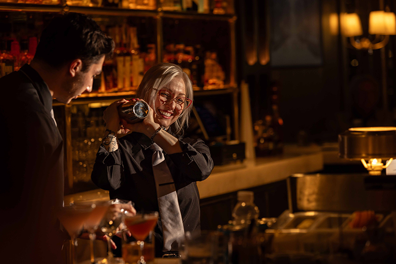 Bar manager Ann Howard shakes a cocktail behind the bar.