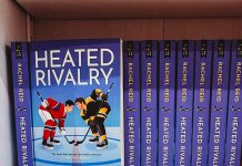 Multiple copies of 'Heated Rivalry' on a bookshelf.