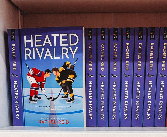 Multiple copies of 'Heated Rivalry' on a bookshelf.
