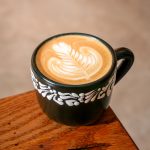 A latte drink adorned with art on the foam.