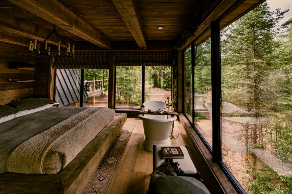 The master suite is fitted with floor-to-ceiling windows, a gas fireplace, and a cast-iron tub. 