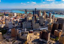 Drone aerial photo of downtown Detroit, Michigan with skyscrapers and the Detroit River on a sunny day.