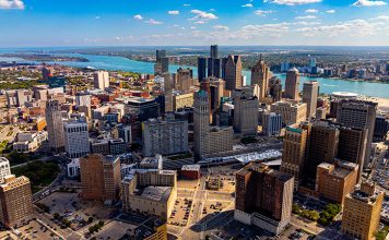 Drone aerial photo of downtown Detroit, Michigan with skyscrapers and the Detroit River on a sunny day.