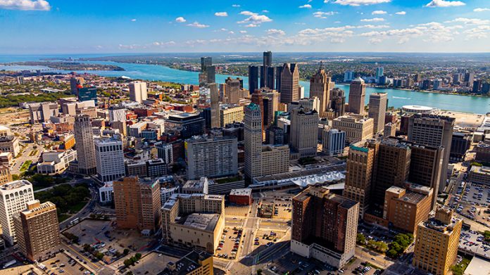 Drone aerial photo of downtown Detroit, Michigan with skyscrapers and the Detroit River on a sunny day.