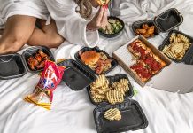 A spread of food on a hotel room bed