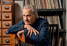 Jeff Daniels posing with a guitar.